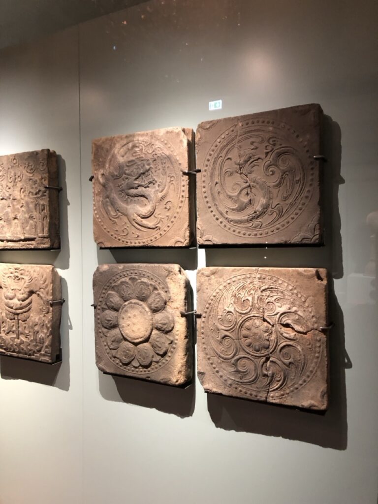 Vier koreanische Fliesen. Motive von. Oben links nach unten rechts: Drache, Phönix, Lotus, Lotus und Wolken